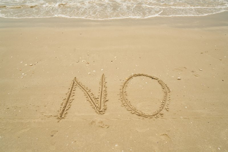 砂浜に書かれたNOの文字