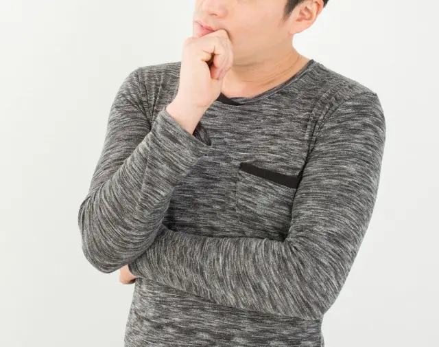 顎に手をあて考える男性